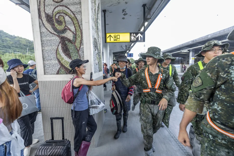 國軍官兵完成災後復原任務，行經車站時與民眾互相致意